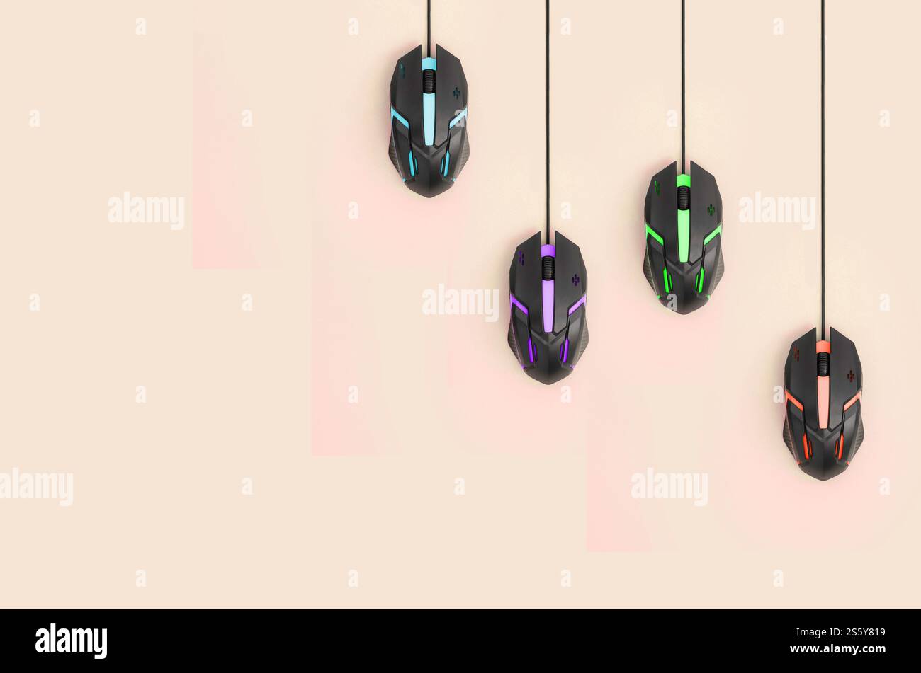 Plusieurs souris d'ordinateur accrochent sur un fond de pêche pastel. Le concept de jeux vidéo informatiques coopératifs, l'utilisation de l'auto-clicker et pay-per-click Banque D'Images