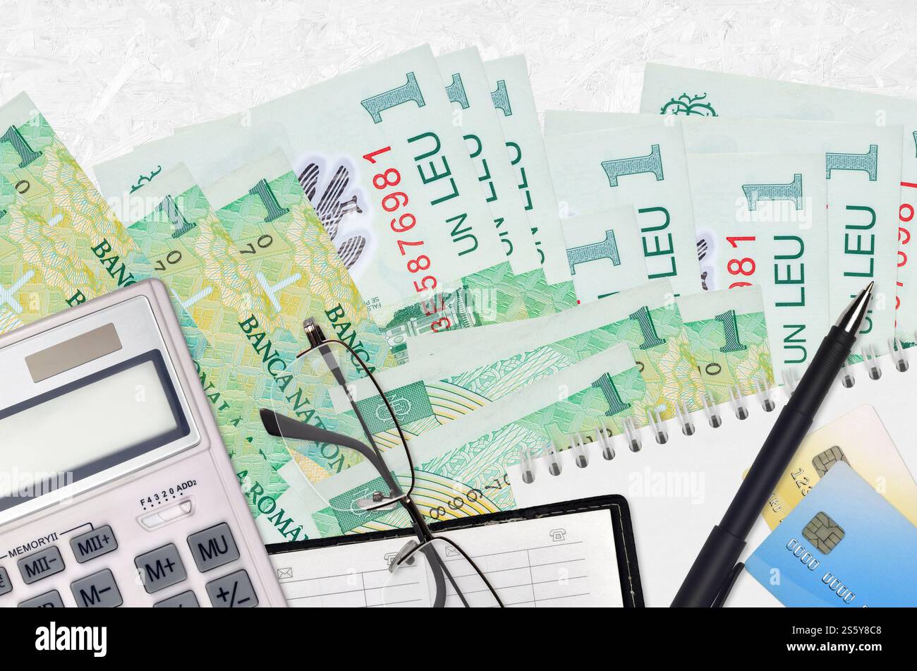 1 billets de leu roumain et calculatrice avec lunettes et stylo. Concept de saison de paiement d'impôt ou solutions d'investissement. Planification financière ou comptable Banque D'Images