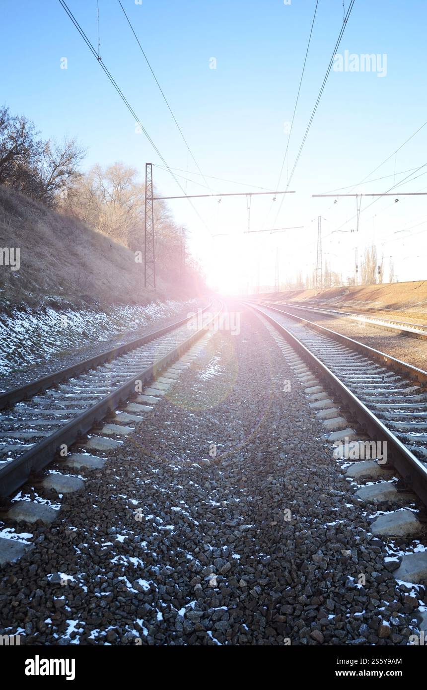 Paysage de neige d'un hiver russe sous la vive lumière du soleil les rails et traverses sous la neige de décembre. Les chemins de fer russes en détail Banque D'Images