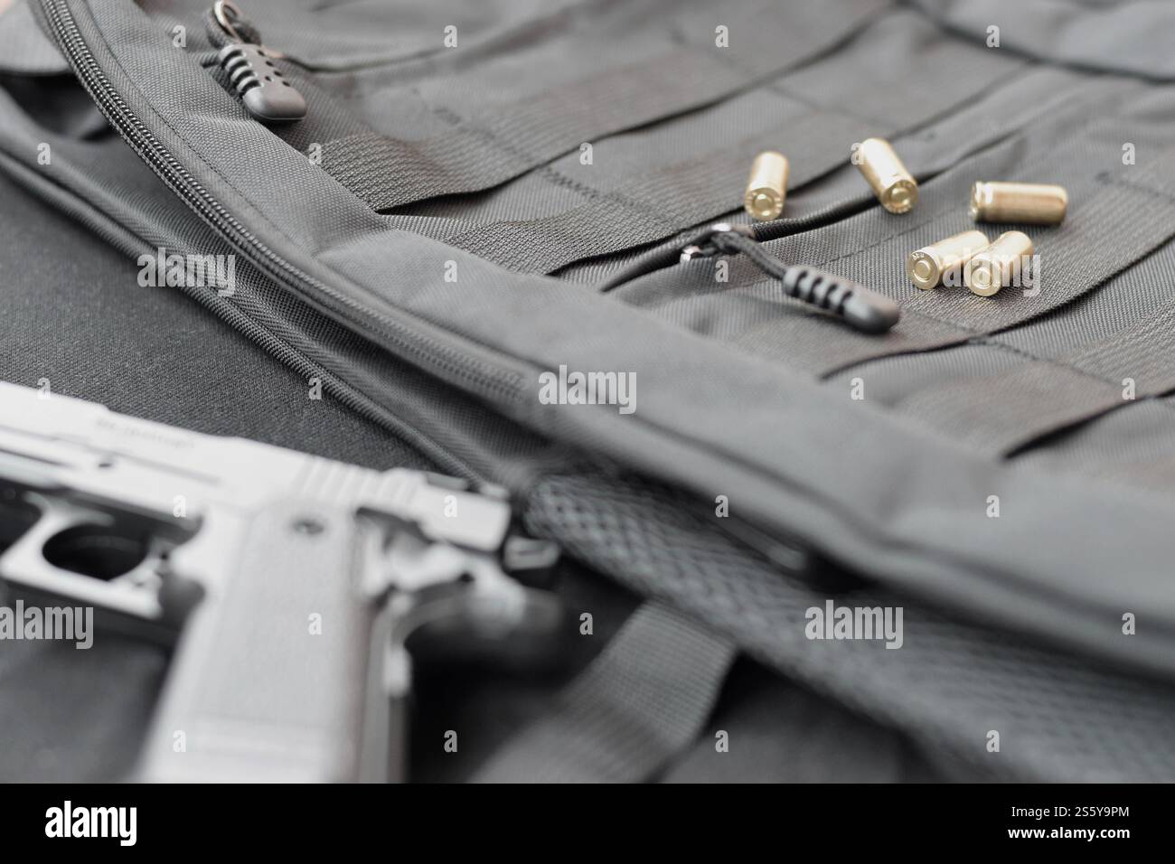 balles de 9mm et pistolet gisent sur un sac à dos tactique noir. Un ensemble d'éléments de service spéciaux ou un agent secret. Des coquillages dorés dispersés autour du Banque D'Images