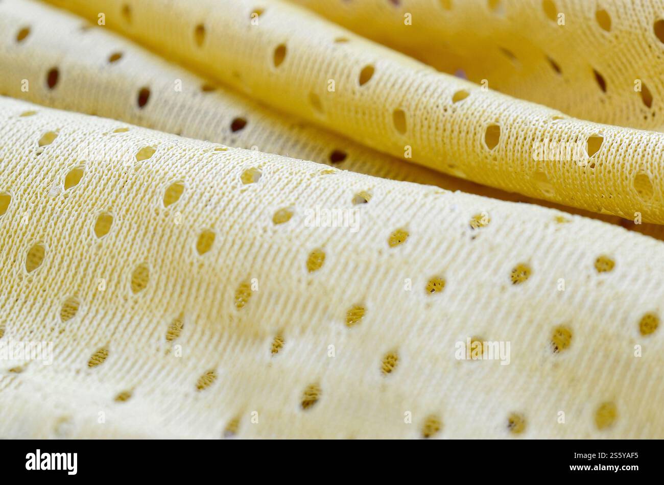 Fond de modèle textile de tissu de tissu de sport de maille jaune. Couleur jaune maillot de football vêtements tissu texture vêtements de sport. Poreux respirant Banque D'Images
