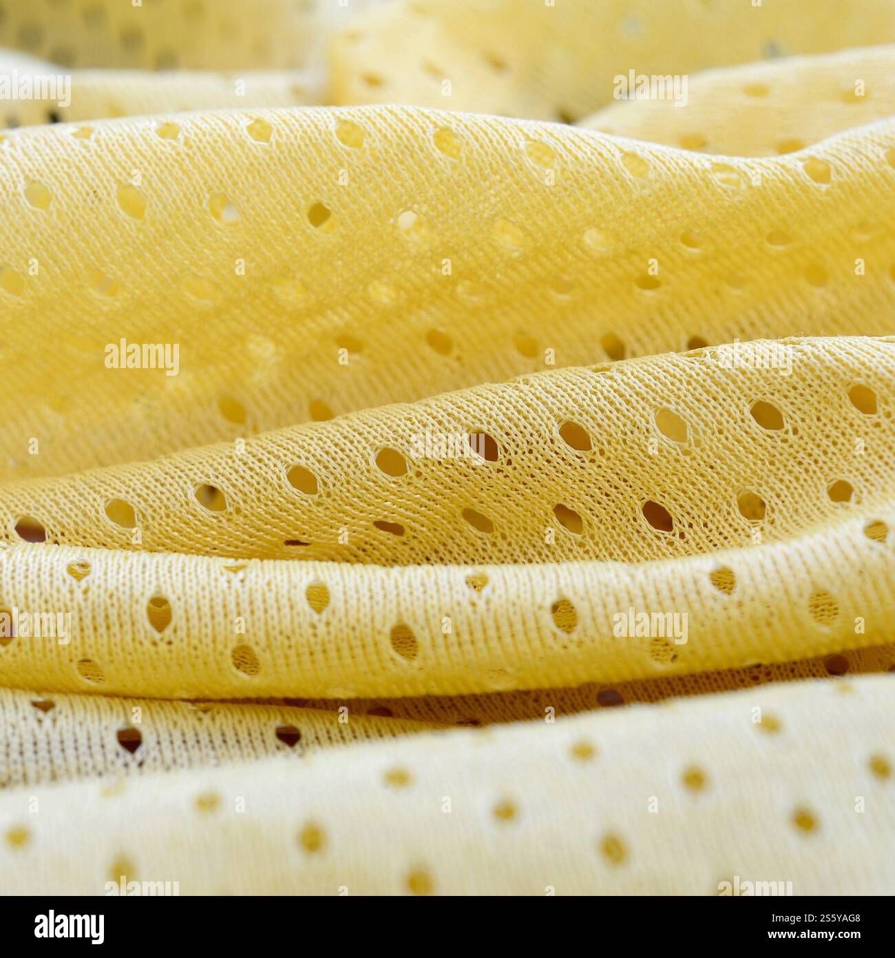 Fond de modèle textile de tissu de tissu de sport de maille jaune. Couleur jaune maillot de football vêtements tissu texture vêtements de sport. Poreux respirant Banque D'Images