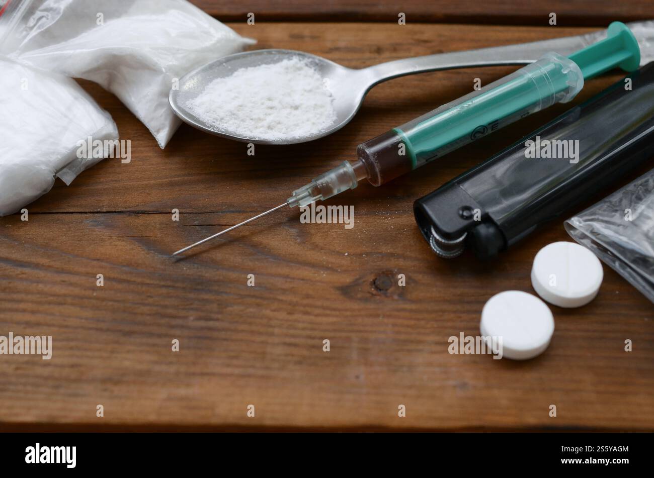 Beaucoup de substances narcotiques et de dispositifs pour la préparation de médicaments reposent sur une vieille table en bois. Trucs de trafiquants de drogue. Héroïne et méthamphétamine dans Banque D'Images