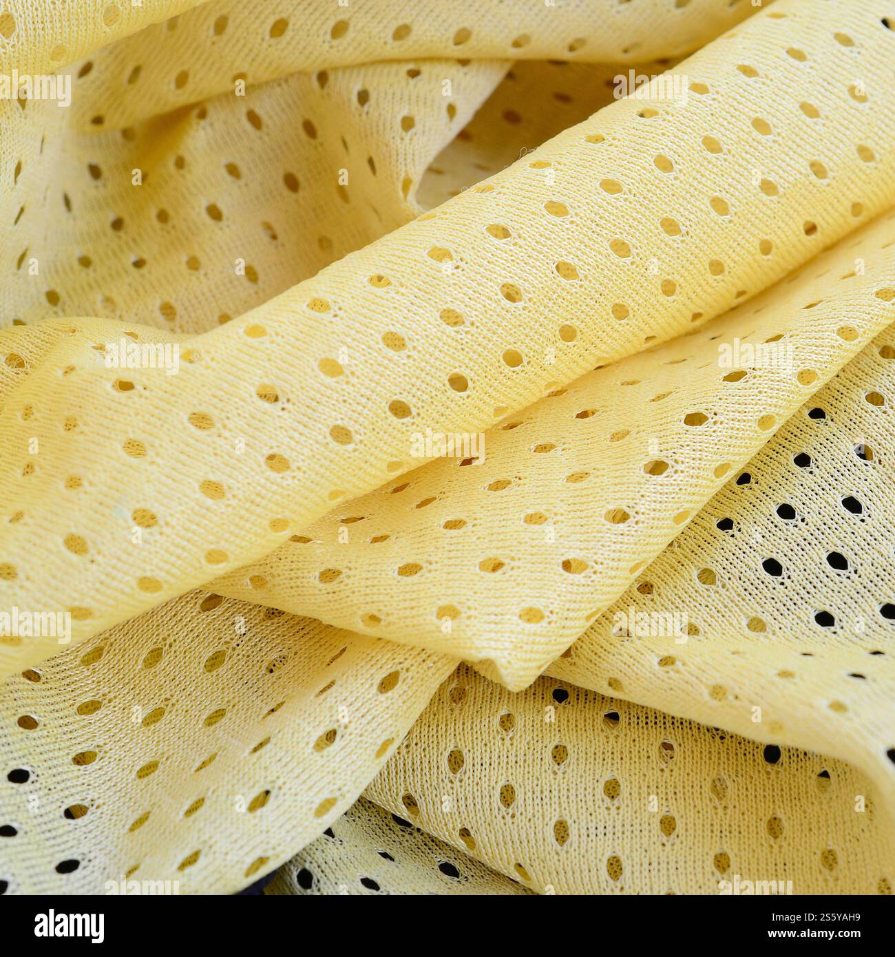 Fond de modèle textile de tissu de tissu de sport de maille jaune. Couleur jaune maillot de football vêtements tissu texture vêtements de sport. Poreux respirant Banque D'Images