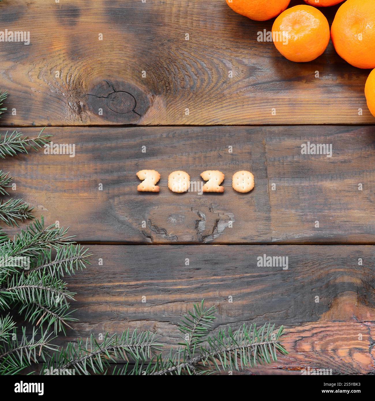Carte de vacances de Noël avec mandarines, craquelin 2020 chiffres et branches de sapin avec espace de copie. Vue de dessus, pose à plat. Mandarines, craquelins 2020 chiffres et Banque D'Images