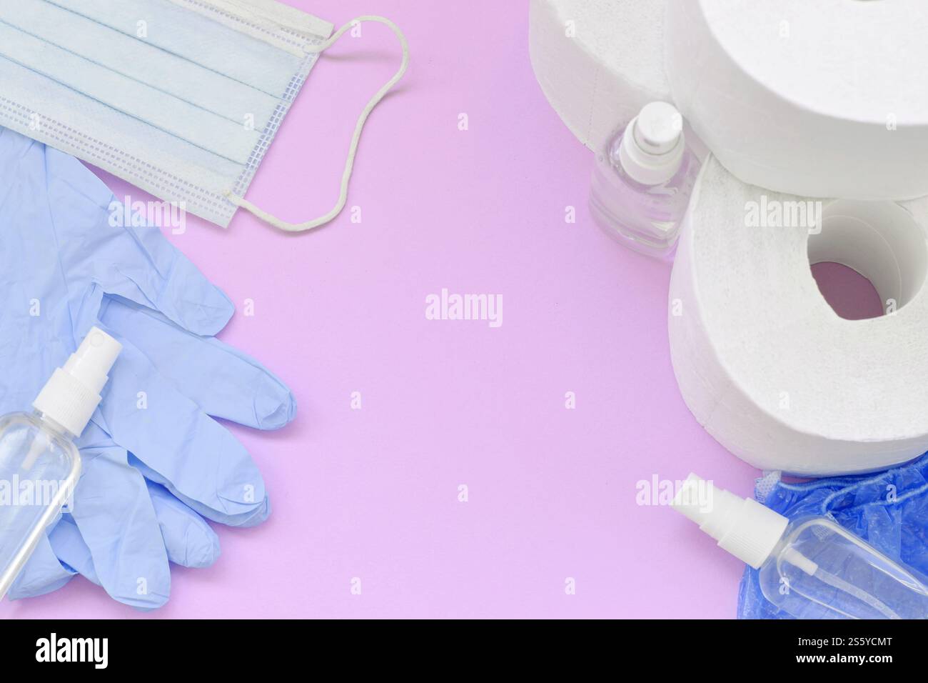 Ensemble d'articles importants pour les heures de quarantaine COVID-19. Papier toilette, gants jetables en caoutchouc avec masque facial chirurgical et désinfectant pour les mains sur lilas Banque D'Images