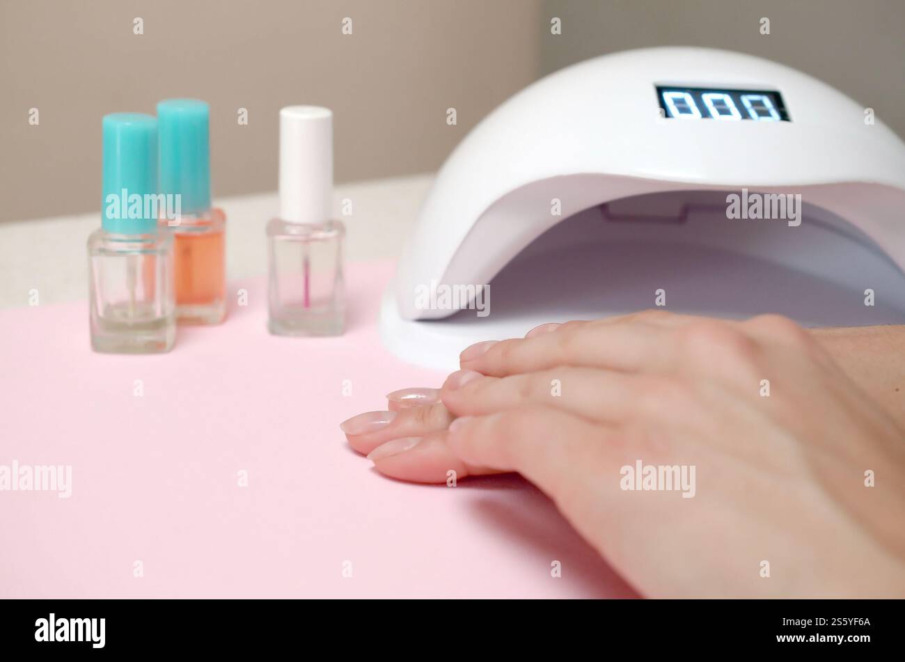 Close up femme mains avec de beaux ongles transparent branché sur l'arrière-plan du tableau blanc. Différents outils modernes pour faire une longue durée polish gel Banque D'Images