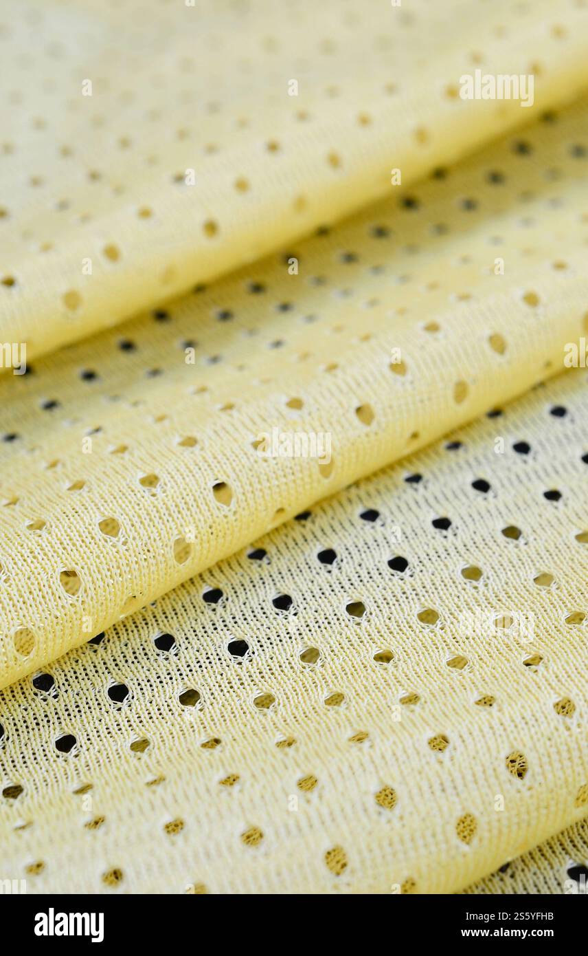 Fond de modèle textile de tissu de tissu de sport de maille jaune. Couleur jaune maillot de football vêtements tissu texture vêtements de sport. Poreux respirant Banque D'Images
