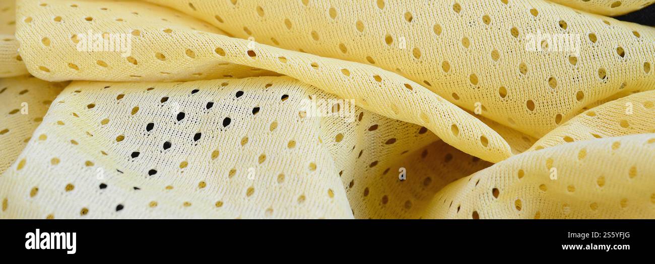 Fond de modèle textile de tissu de tissu de sport de maille jaune. Couleur jaune maillot de football vêtements tissu texture vêtements de sport. Poreux respirant Banque D'Images