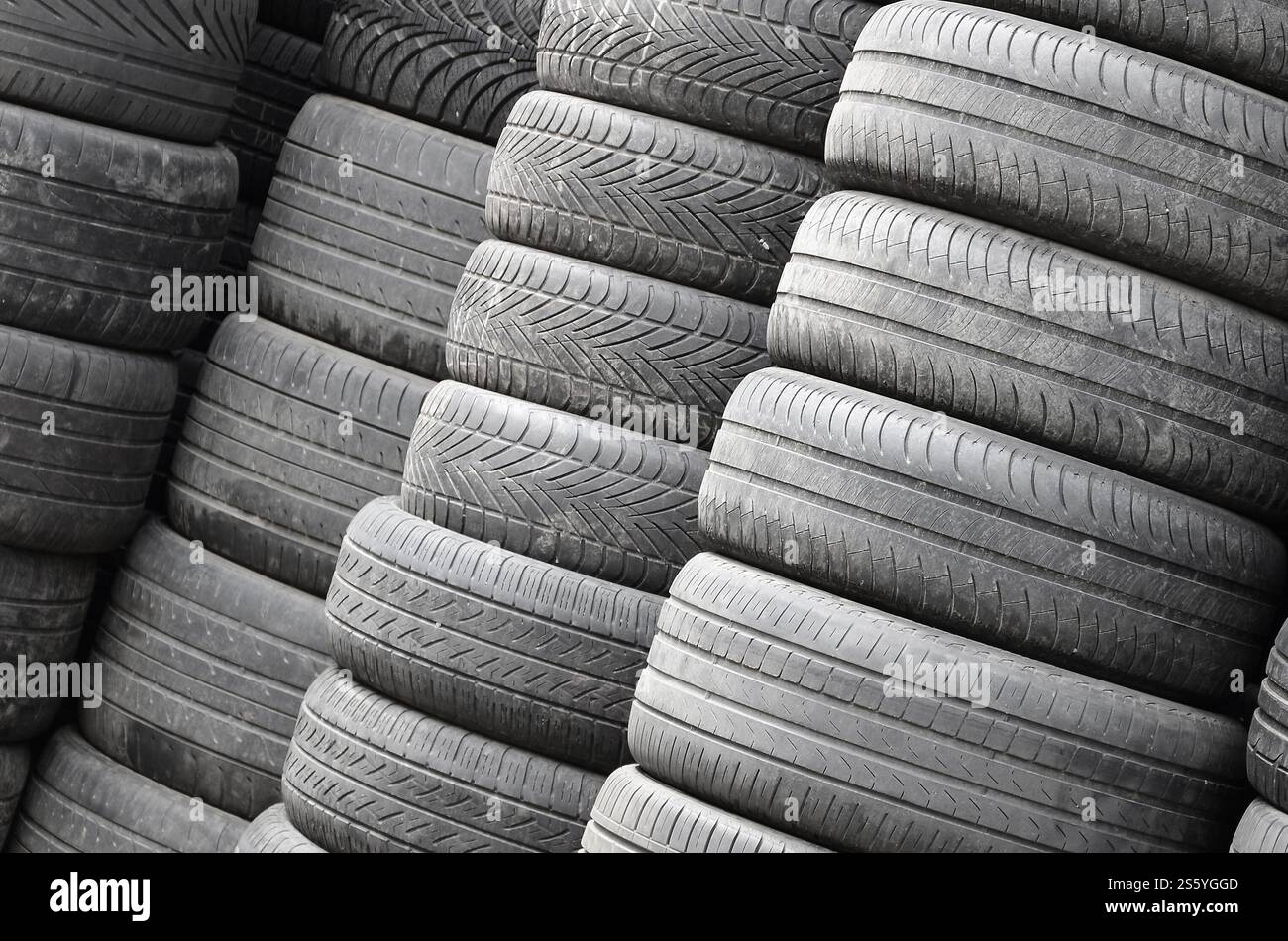 Vieux pneus usagés empilés avec des piles élevées dans le garage secondaire de magasin de pièces de voiture de près. Vieux pneus usagés empilés avec des piles élevées dans des pièces de voiture secondaires Banque D'Images