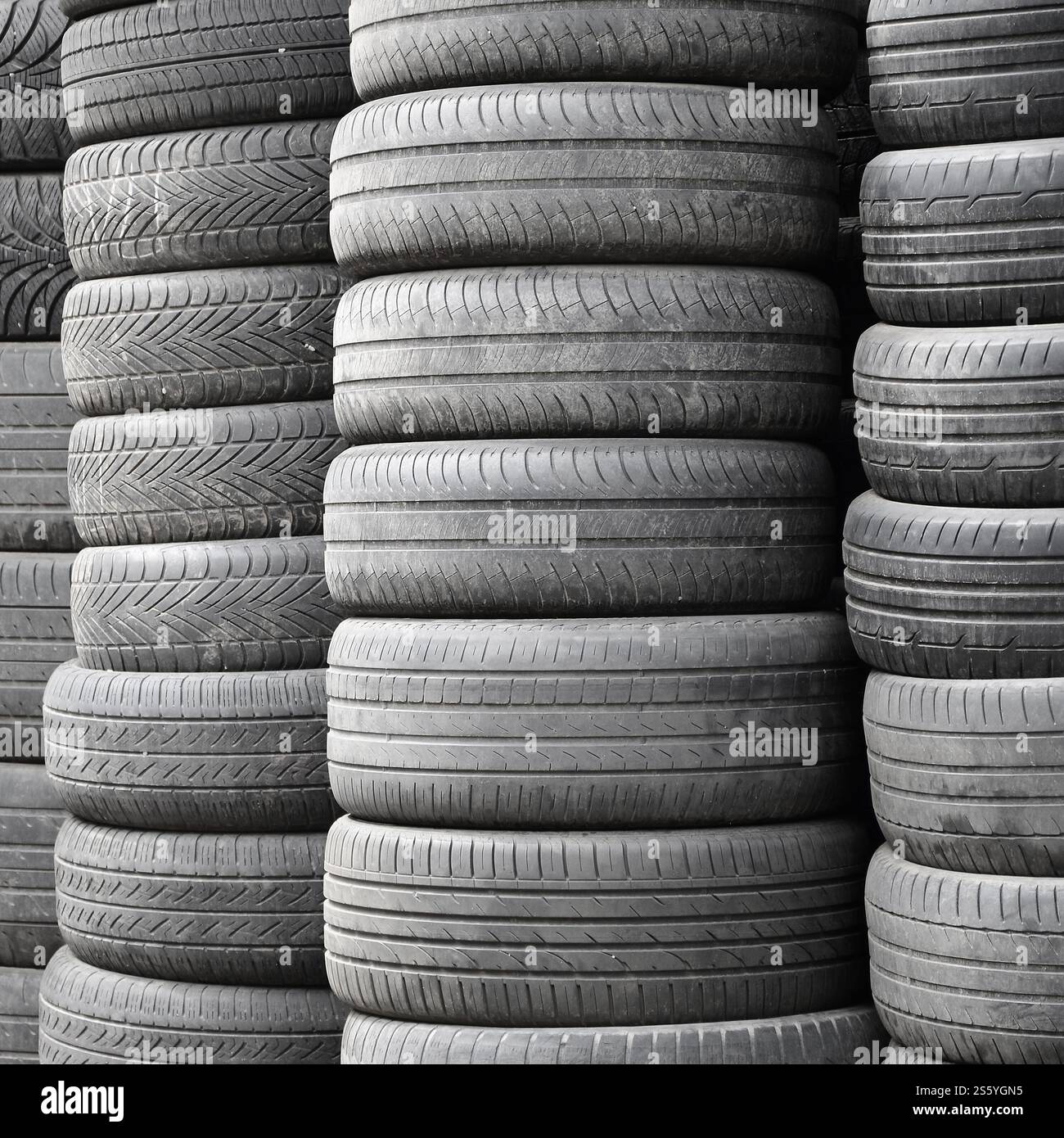 Vieux pneus usagés empilés avec des piles élevées dans le garage secondaire de magasin de pièces de voiture de près. Vieux pneus usagés empilés avec des piles élevées dans des pièces de voiture secondaires Banque D'Images