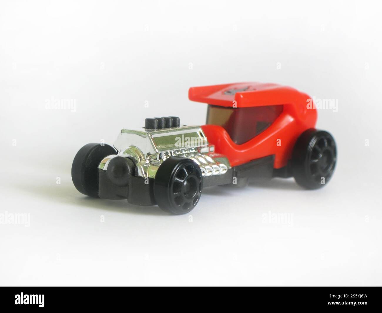 Petite voiture jouet en plastique rouge isolé sur fond blanc Banque D'Images