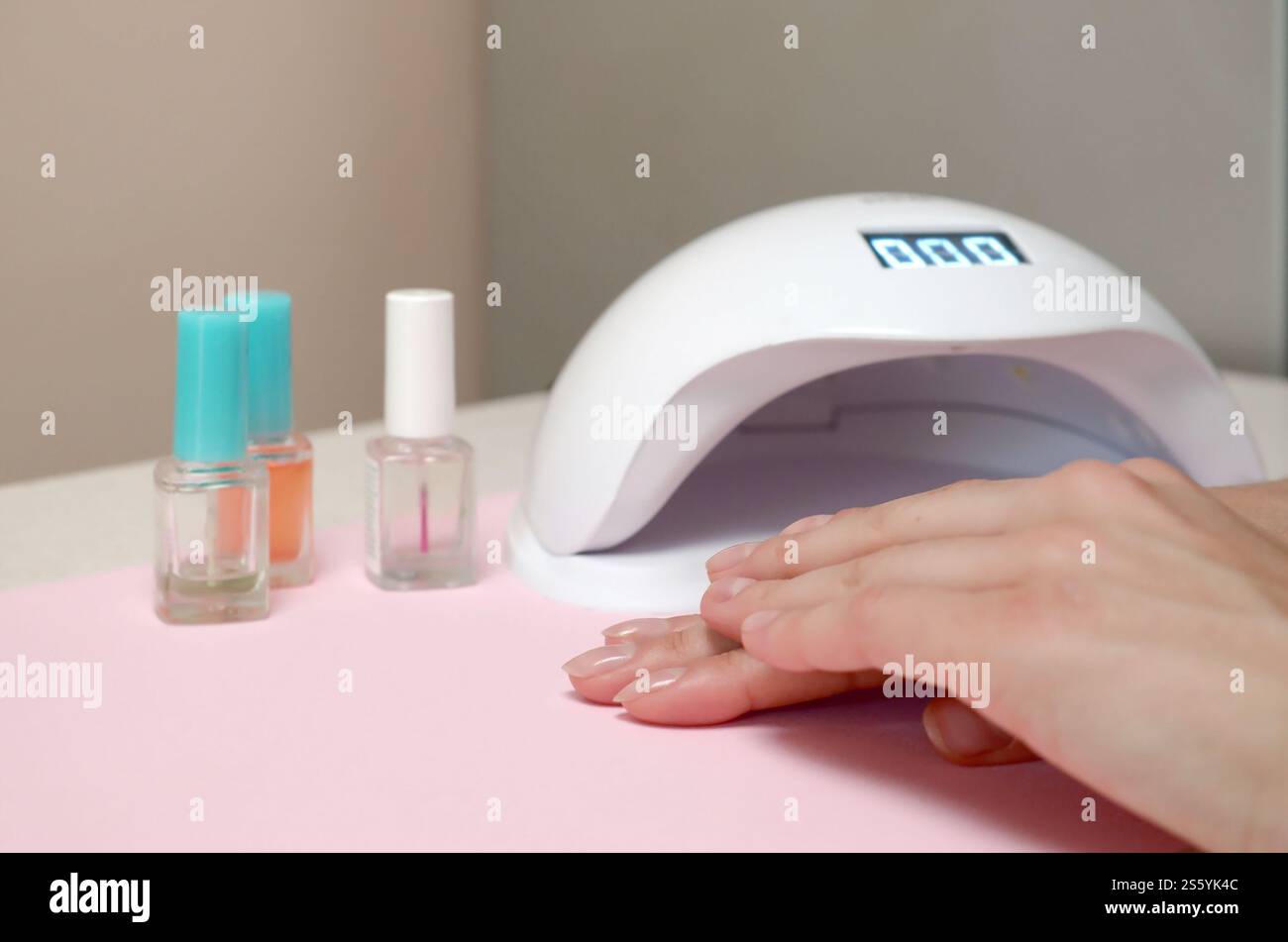 Close up femme mains avec de beaux ongles transparent branché sur l'arrière-plan du tableau blanc. Différents outils modernes pour faire une longue durée polish gel Banque D'Images
