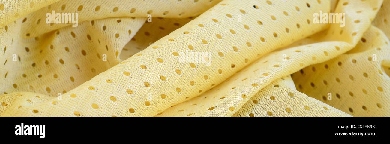 Fond de modèle textile de tissu de tissu de sport de maille jaune. Couleur jaune maillot de football vêtements tissu texture vêtements de sport. Poreux respirant Banque D'Images