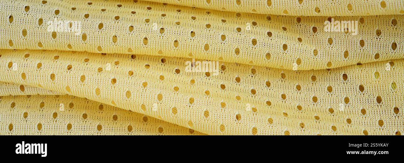 Fond de modèle textile de tissu de tissu de sport de maille jaune. Couleur jaune maillot de football vêtements tissu texture vêtements de sport. Poreux respirant Banque D'Images