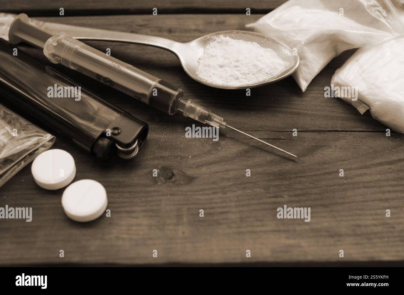 Beaucoup de substances narcotiques et de dispositifs pour la préparation de médicaments reposent sur une vieille table en bois. Trucs de trafiquants de drogue. Héroïne et méthamphétamine dans Banque D'Images