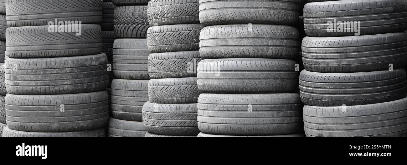 Vieux pneus usagés empilés avec des piles élevées dans le garage secondaire de magasin de pièces de voiture de près. Vieux pneus usagés empilés avec des piles élevées dans des pièces de voiture secondaires Banque D'Images
