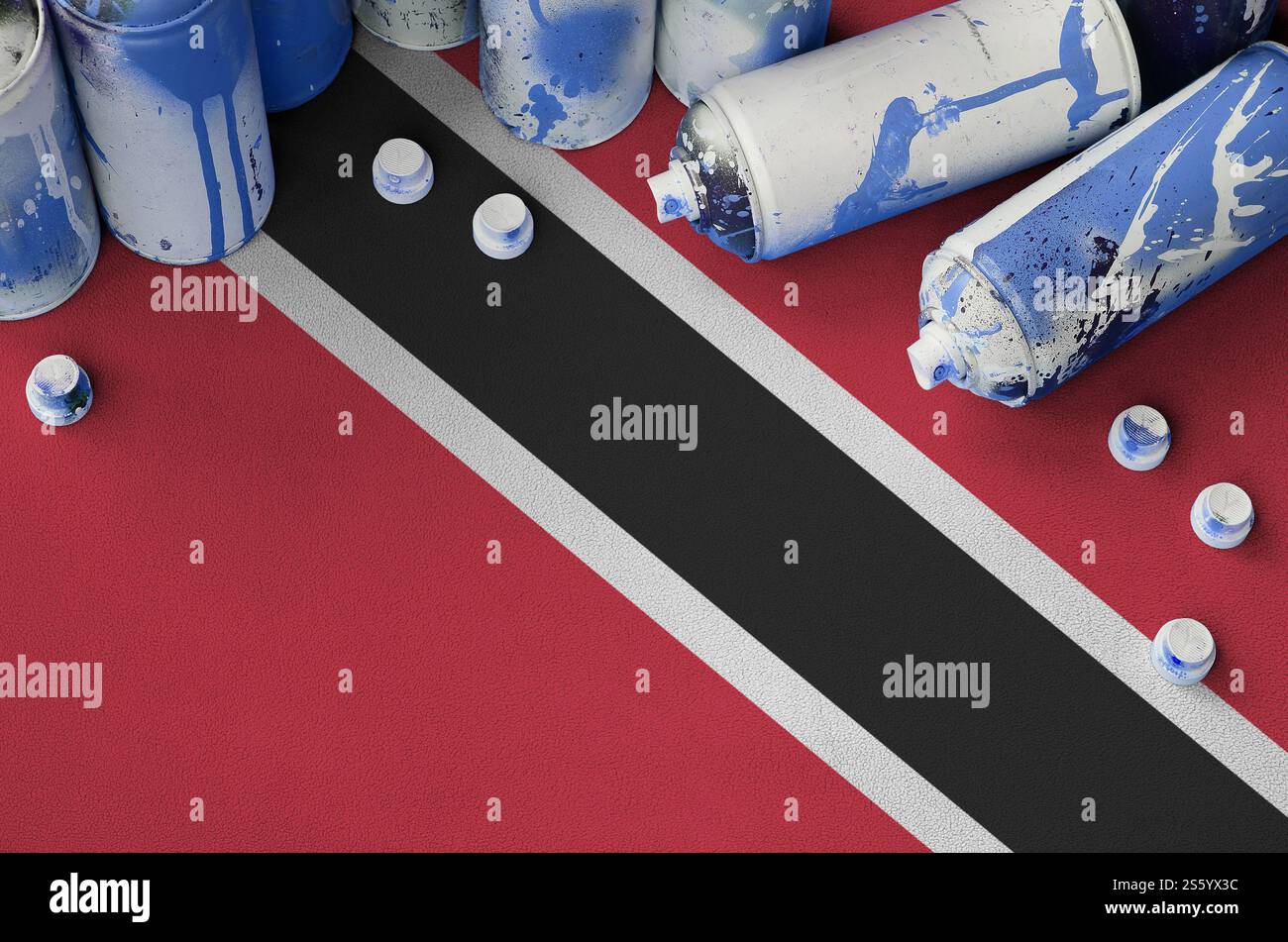 Trinité-et-Tobago drapeau et peu utilisé des bombes aérosol pour la peinture de graffiti. Concept de culture Street art, problèmes de vandalisme. Trinité-et-Tobago Banque D'Images