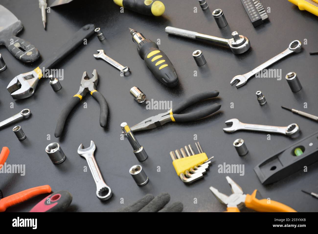 Kit d'outils bricoleur sur table en bois noir. De nombreuses clés et tournevis, pilers et autres outils pour tout type de travaux de réparation ou de construction. Banque D'Images