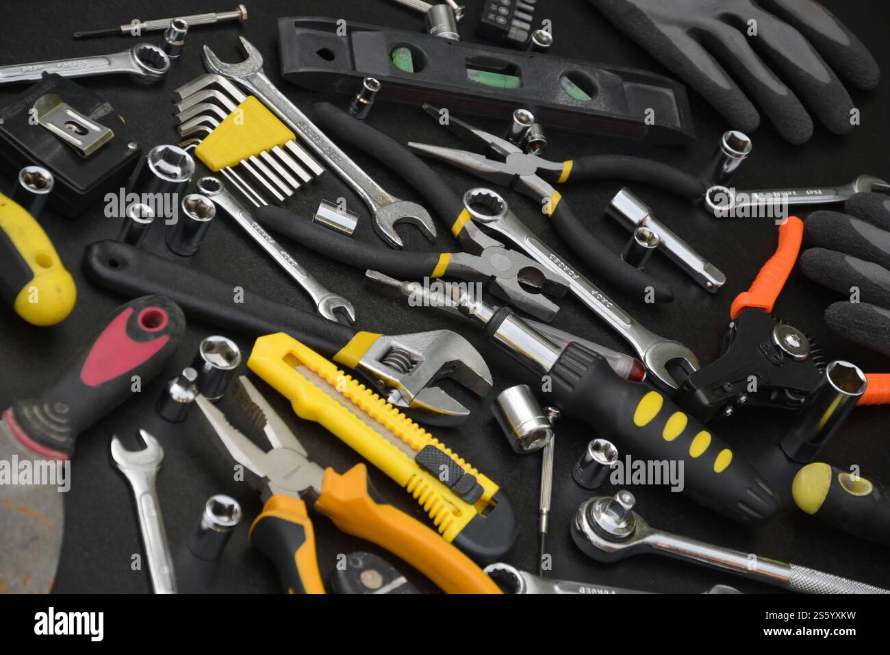 Kit d'outils bricoleur sur table en bois noir. De nombreuses clés et tournevis, pilers et autres outils pour tout type de travaux de réparation ou de construction. Banque D'Images