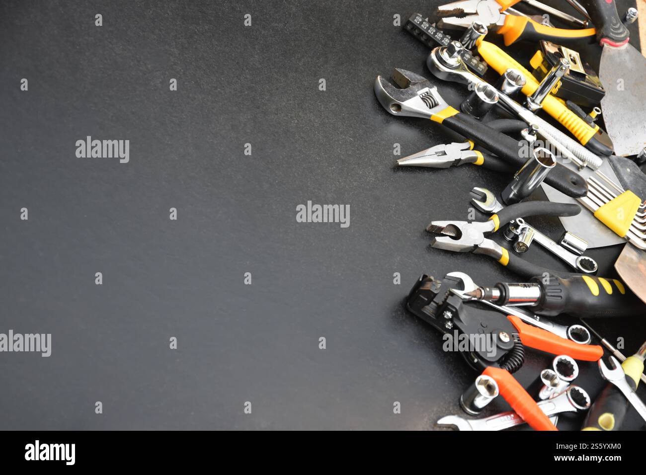 Kit d'outils bricoleur sur table en bois noir. De nombreuses clés et tournevis, pilers et autres outils pour tout type de travaux de réparation ou de construction. Banque D'Images