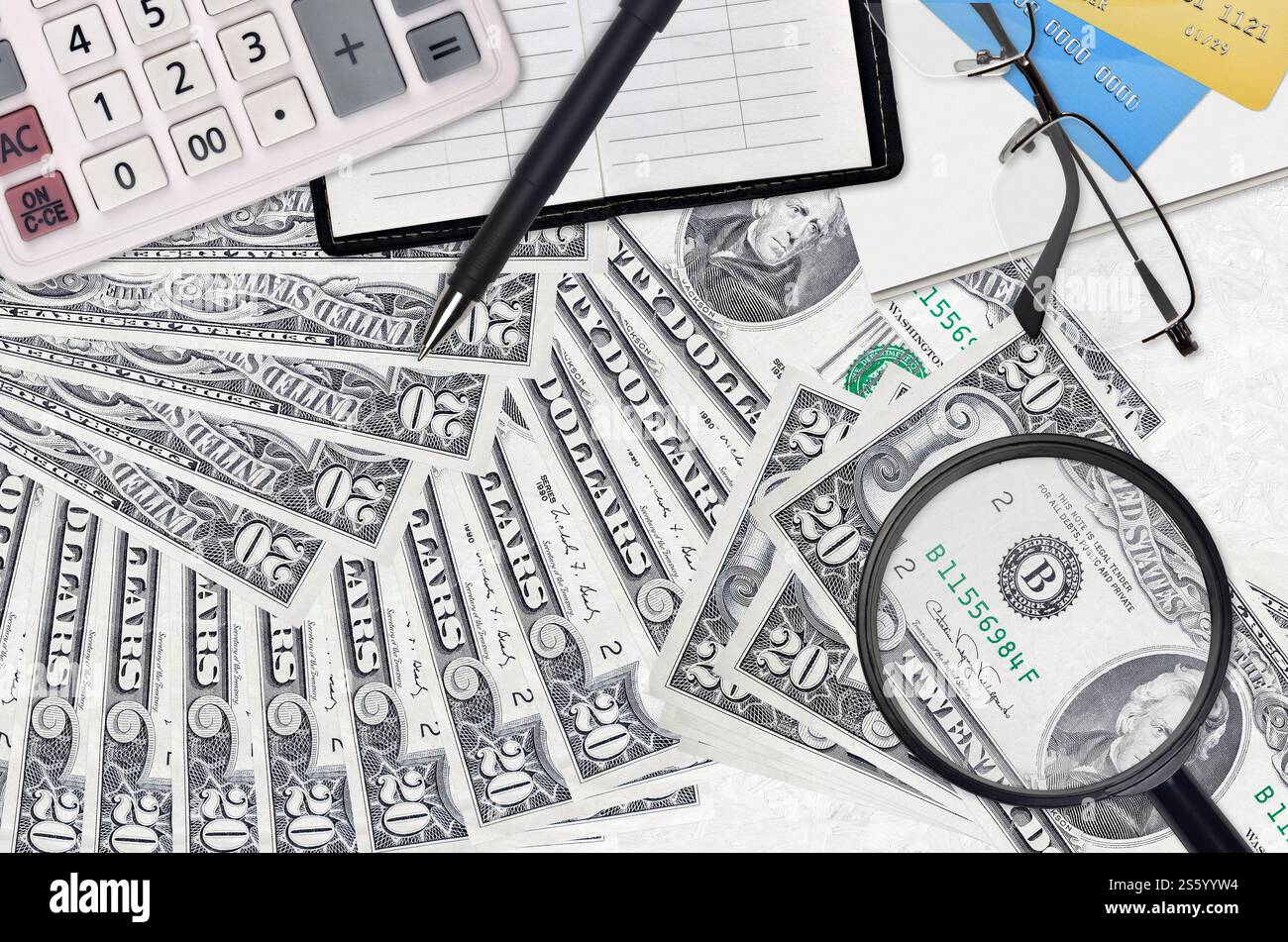 Billets de 20 dollars américains et calculatrice avec lunettes et stylo. Concept de saison de paiement d'impôt ou solutions d'investissement. Recherche d'un emploi avec un salaire élevé Banque D'Images