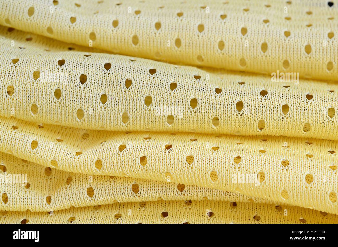 Fond de modèle textile de tissu de tissu de sport de maille jaune. Couleur jaune maillot de football vêtements tissu texture vêtements de sport. Poreux respirant Banque D'Images