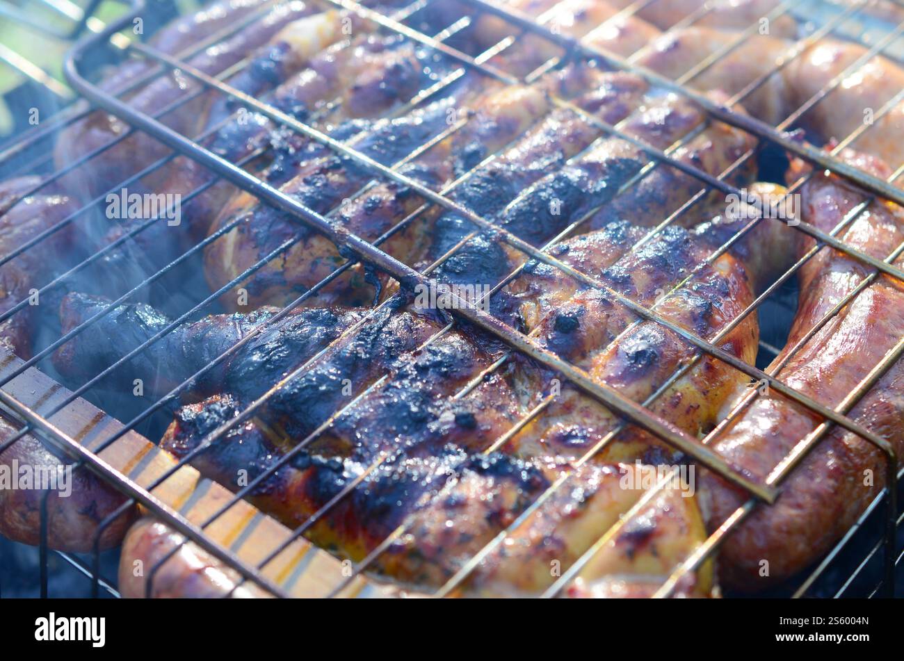 Viande grillée avec croûte trop cuite. Cuisses de poulet marinées sur le barbecue chaud au charbon de bois Grill mauvaise cuisson et mauvaise viande sur le feu. Mauvais et inapproprié Banque D'Images