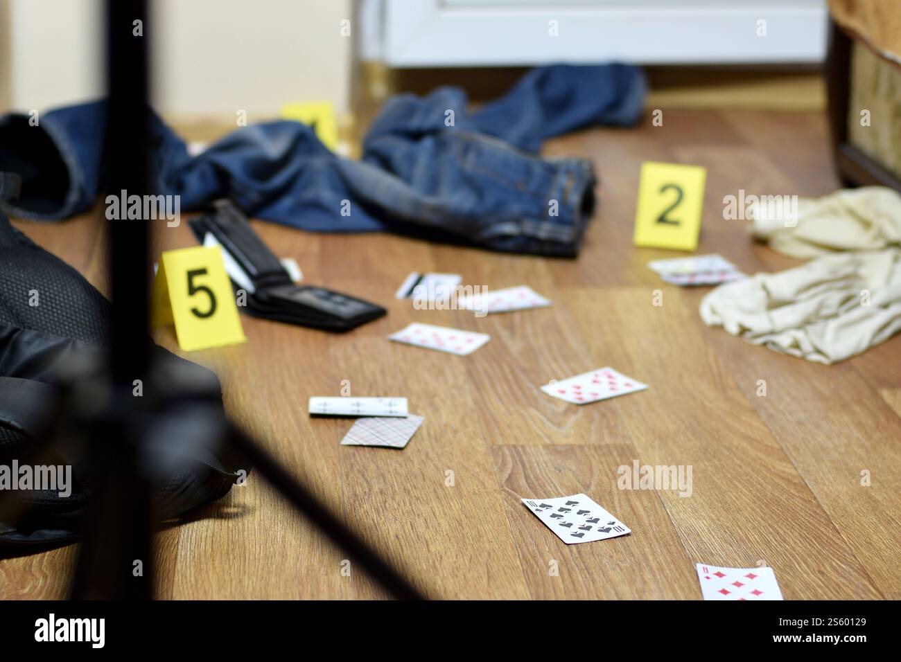 Enquête sur les lieux du crime - numérotation des preuves après le meurtre dans l'appartement. Beaucoup de cartes à jouer, portefeuille et vêtements avec des preuves Banque D'Images