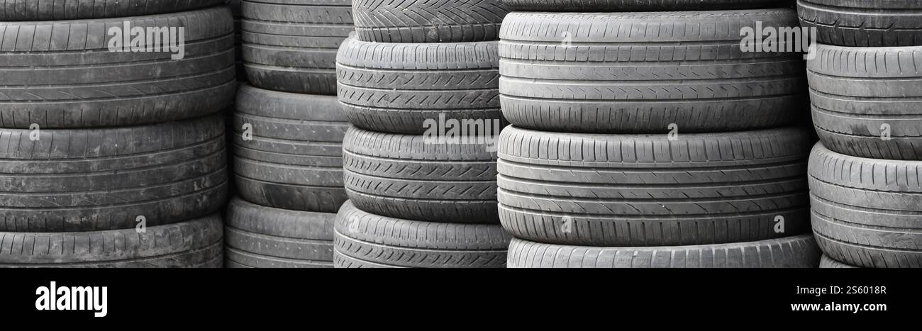 Vieux pneus usagés empilés avec des piles élevées dans le garage secondaire de magasin de pièces de voiture de près. Vieux pneus usagés empilés avec des piles élevées dans des pièces de voiture secondaires Banque D'Images