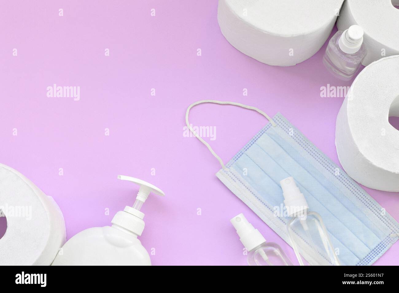 Ensemble d'articles importants pour les heures de quarantaine COVID-19. Papier toilette avec masque facial chirurgical et désinfectant pour les mains avec bouteille de savon liquide sur lilas Banque D'Images