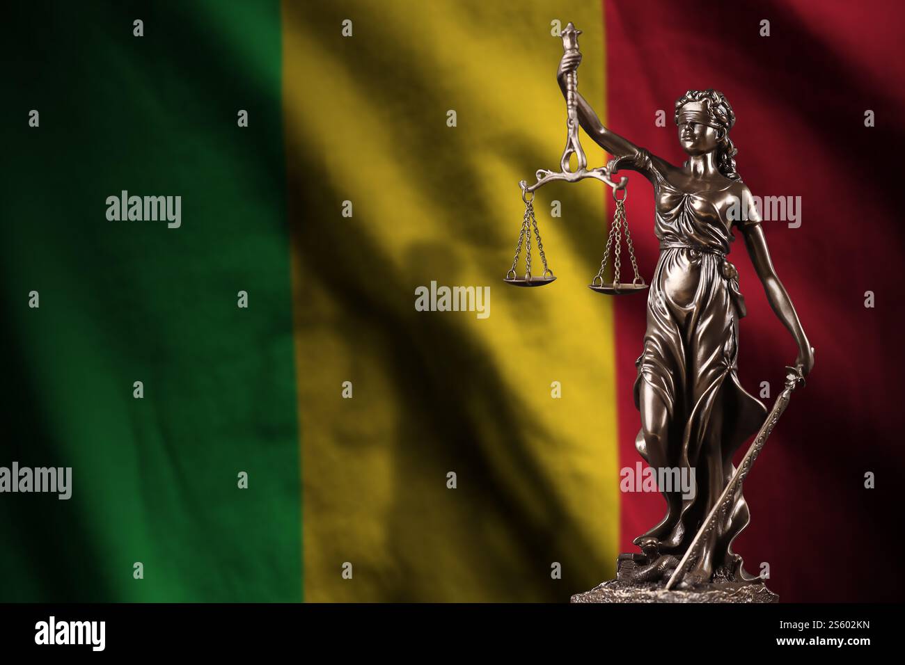 Drapeau du Mali avec statue de la justice de dame et balances judiciaires dans la chambre noire. Concept de jugement et de punition, contexte pour les sujets de jury. Drapeau du Mali Banque D'Images
