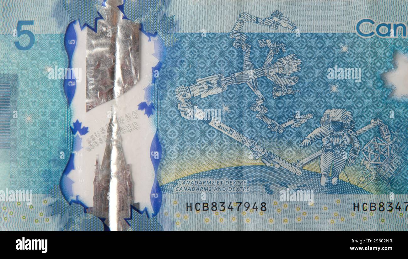 Dextre et canadarm2 on Canada 5 dollars 2013 fragment de billet de banque polymère gros plan. Dextre et canadarm2 sur billet de banque Canada 5 dollars 2013 en polymère Banque D'Images Dextre et canadarm2 on Canada 5 dollars 2013 fragment de billet de banque polymère gros plan. Dextre et canadarm2 sur billet de banque Canada 5 dollars 2013 en polymère Banque D'Images
