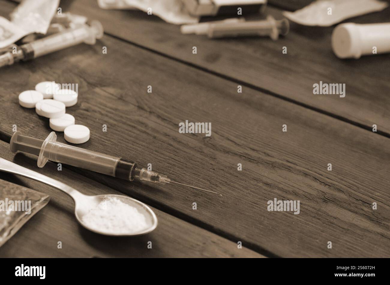 Beaucoup de substances narcotiques et de dispositifs pour la préparation de médicaments reposent sur une vieille table en bois. Trucs de trafiquants de drogue. Héroïne et méthamphétamine dans Banque D'Images