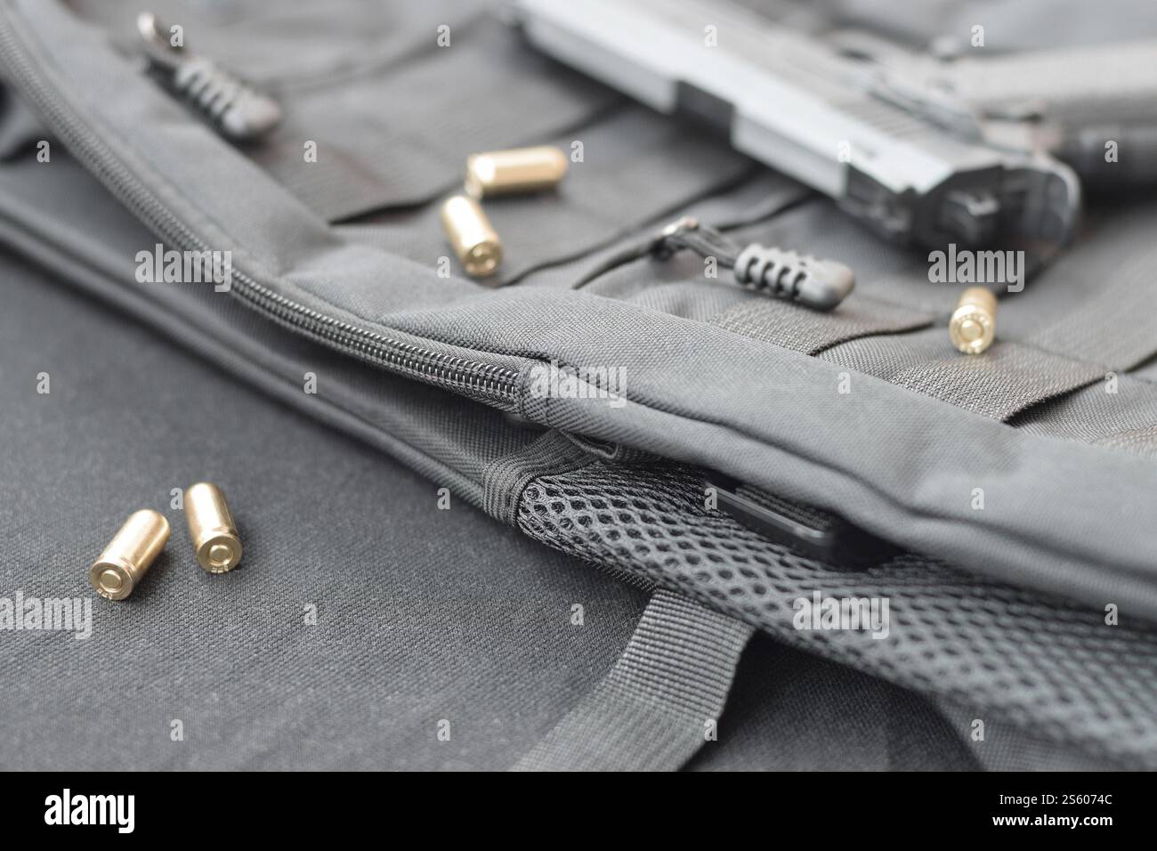 balles de 9mm et pistolet gisent sur un sac à dos tactique noir. Un ensemble d'éléments de service spéciaux ou un agent secret. Des coquillages dorés dispersés autour du Banque D'Images