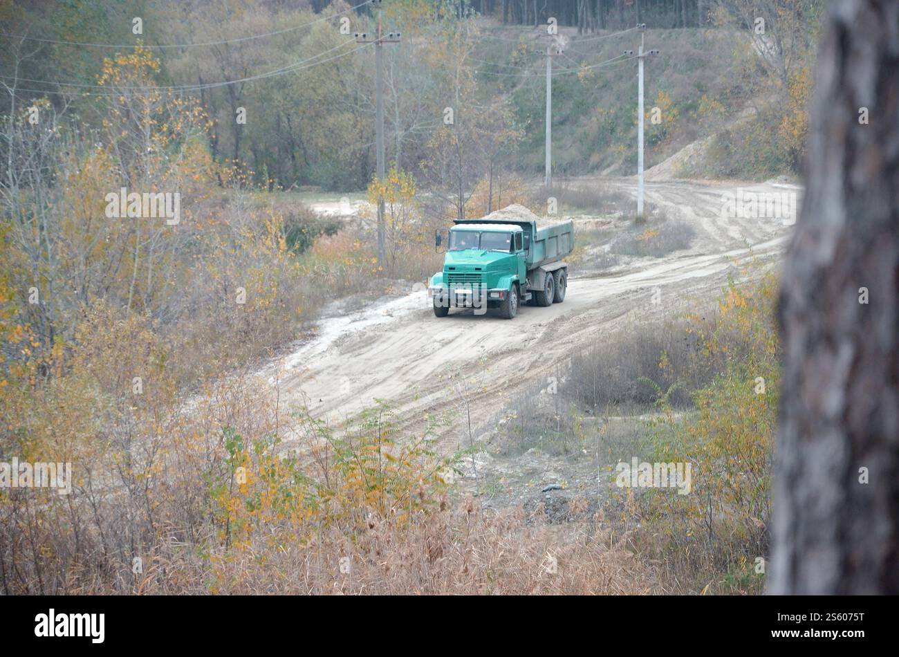 Le camion à benne basculante transporte du sable et d'autres minéraux dans la carrière minière. Industrie lourde et transport des ressources. Camion à benne basculante transporte du sable et autre Banque D'Images
