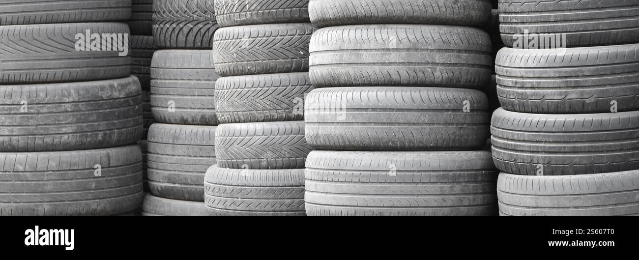 Vieux pneus usagés empilés avec des piles élevées dans le garage secondaire de magasin de pièces de voiture de près. Vieux pneus usagés empilés avec des piles élevées dans des pièces de voiture secondaires Banque D'Images