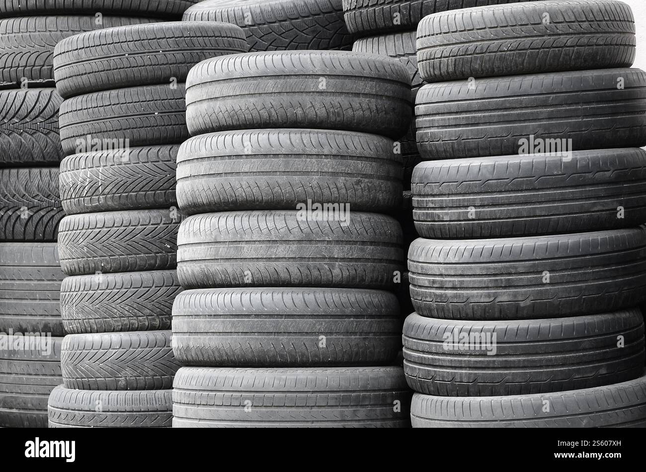 Vieux pneus usagés empilés avec des piles élevées dans le garage secondaire de magasin de pièces de voiture de près. Vieux pneus usagés empilés avec des piles élevées dans des pièces de voiture secondaires Banque D'Images