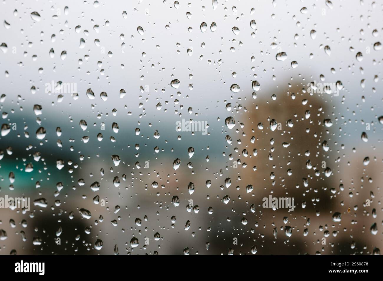 Gouttes de pluie sur la fenêtre d'un appartement. Gros plan, photo macro, bâtiment de ville floue en arrière-plan, pas de gens. Banque D'Images
