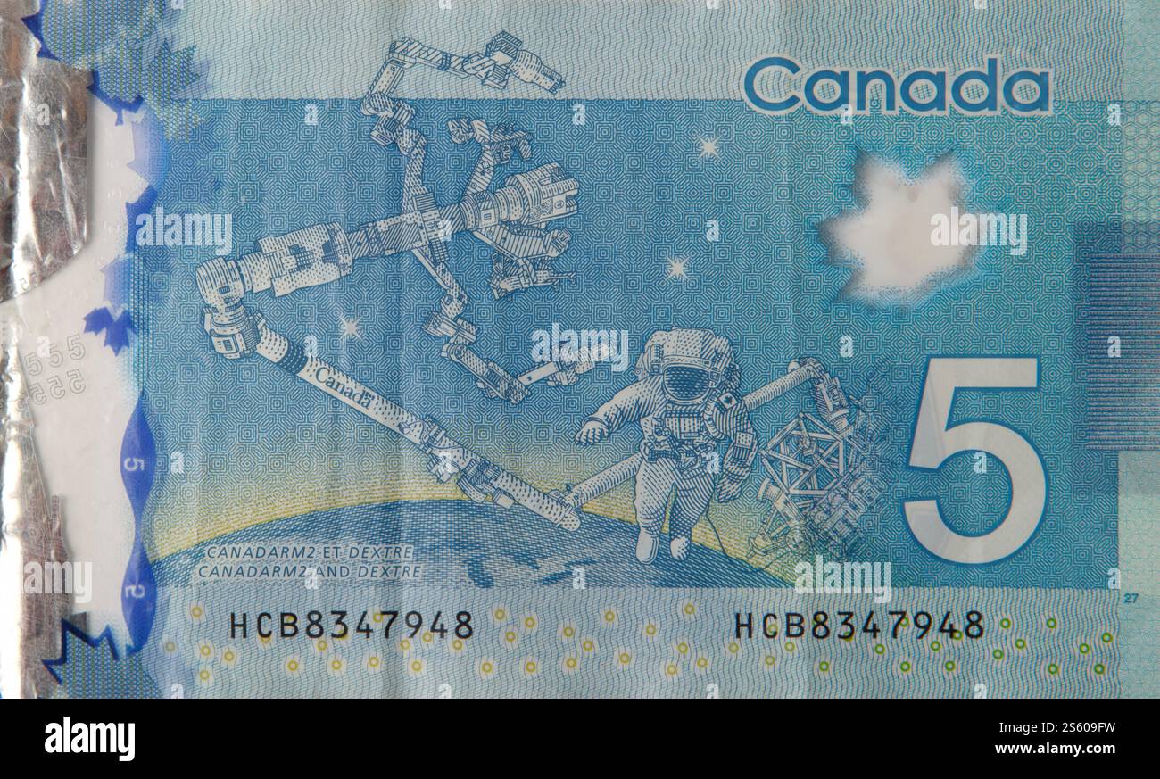 Dextre et canadarm2 on Canada 5 dollars 2013 fragment de billet de banque polymère gros plan. Dextre et canadarm2 sur billet de banque Canada 5 dollars 2013 en polymère Banque D'Images Dextre et canadarm2 on Canada 5 dollars 2013 fragment de billet de banque polymère gros plan. Dextre et canadarm2 sur billet de banque Canada 5 dollars 2013 en polymère Banque D'Images