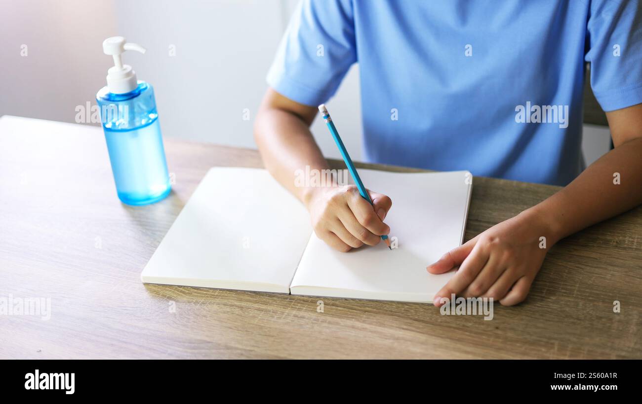 Jeune femme asiatique portant le masque médical fait à la main du visage travaillant seule politique de distanciation avec. Gel désinfectant pour les mains pendant le coronavirus ou le virus covid-19 Banque D'Images