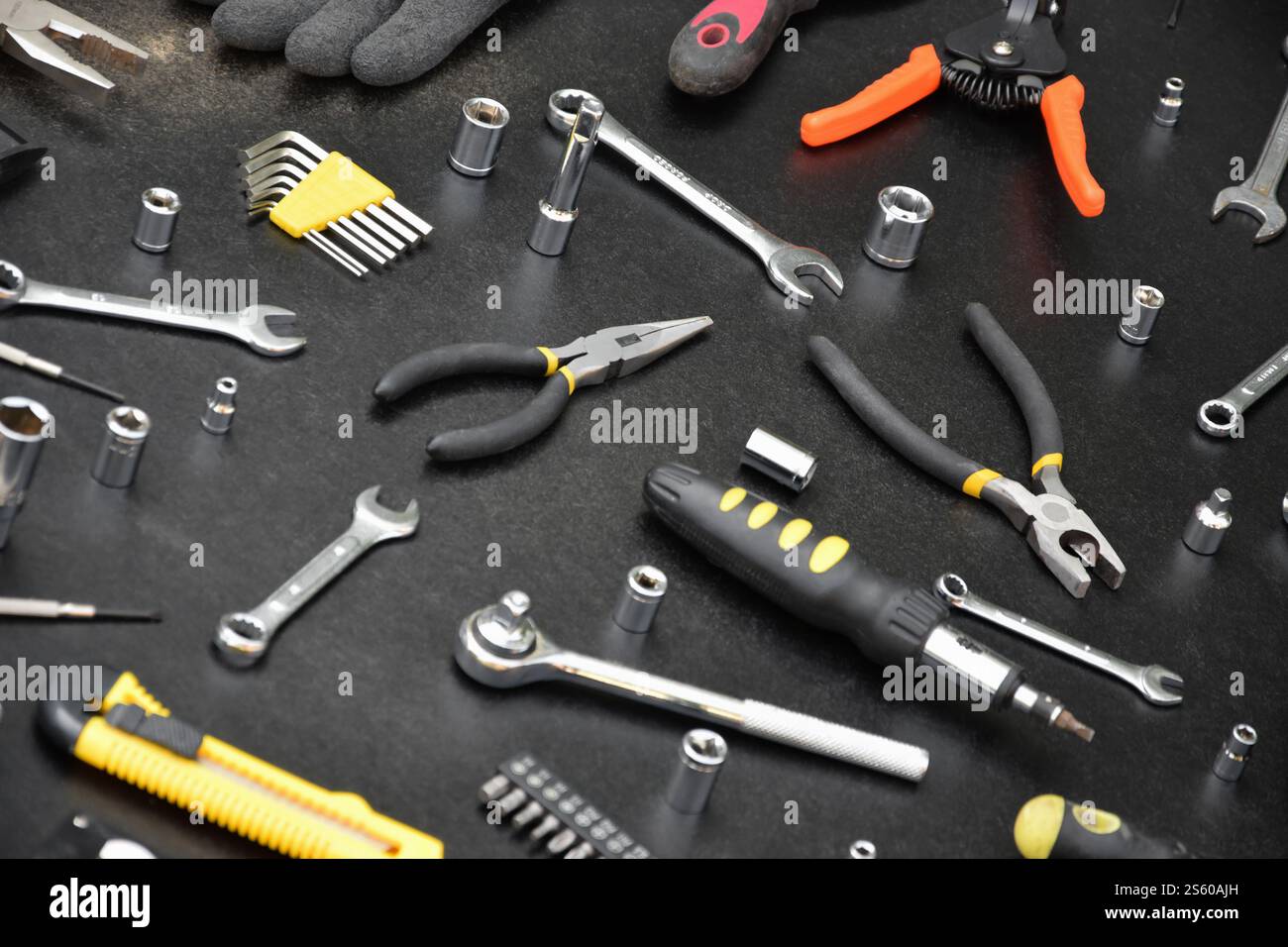 Kit d'outils bricoleur sur table en bois noir. De nombreuses clés et tournevis, pilers et autres outils pour tout type de travaux de réparation ou de construction. Banque D'Images