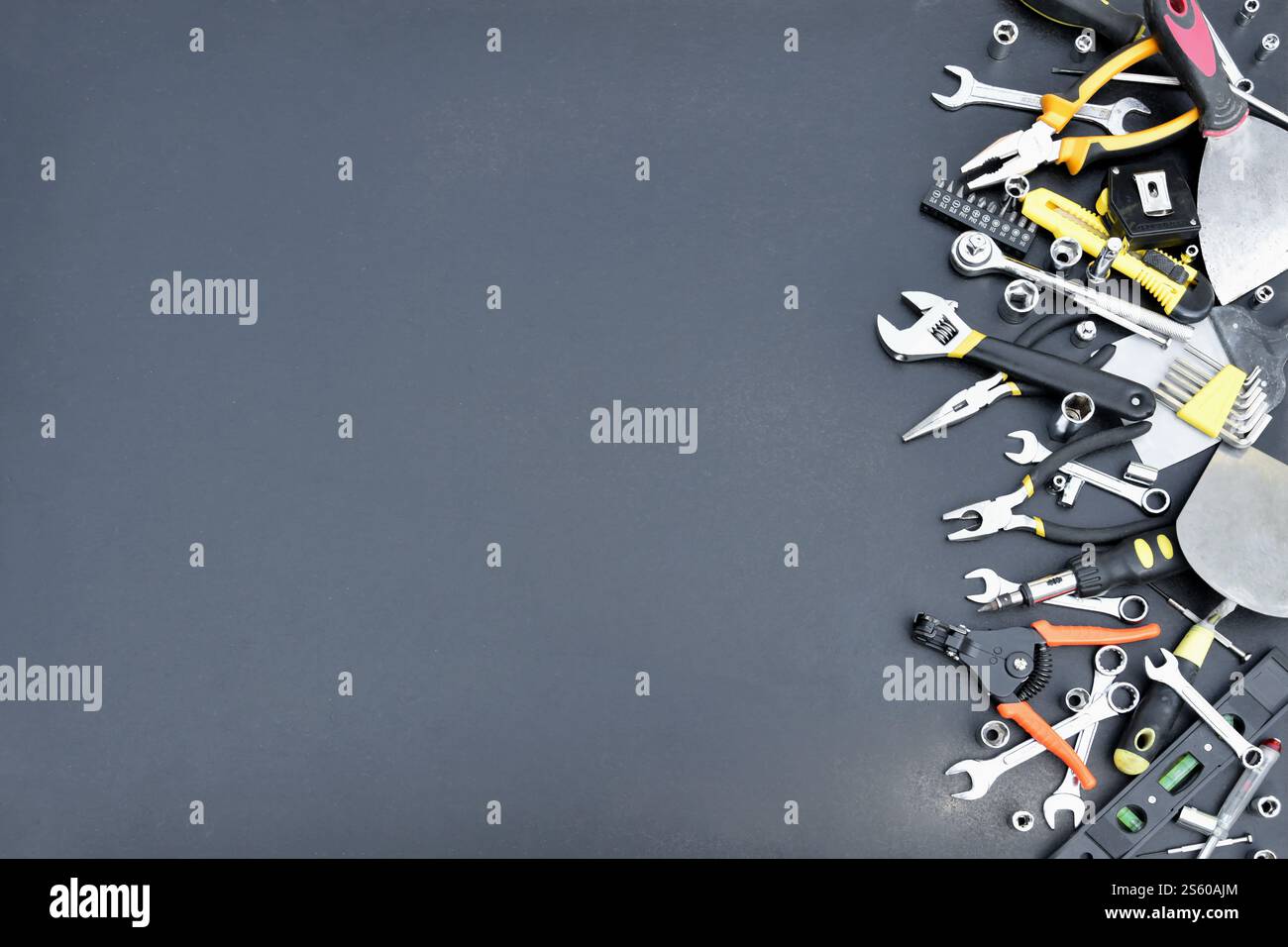 Kit d'outils bricoleur sur table en bois noir. De nombreuses clés et tournevis, pilers et autres outils pour tout type de travaux de réparation ou de construction. Banque D'Images