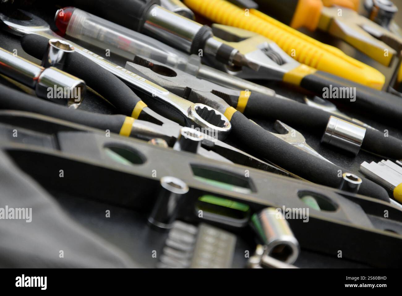 Kit d'outils bricoleur sur table en bois noir. De nombreuses clés et tournevis, pilers et autres outils pour tout type de travaux de réparation ou de construction. Banque D'Images
