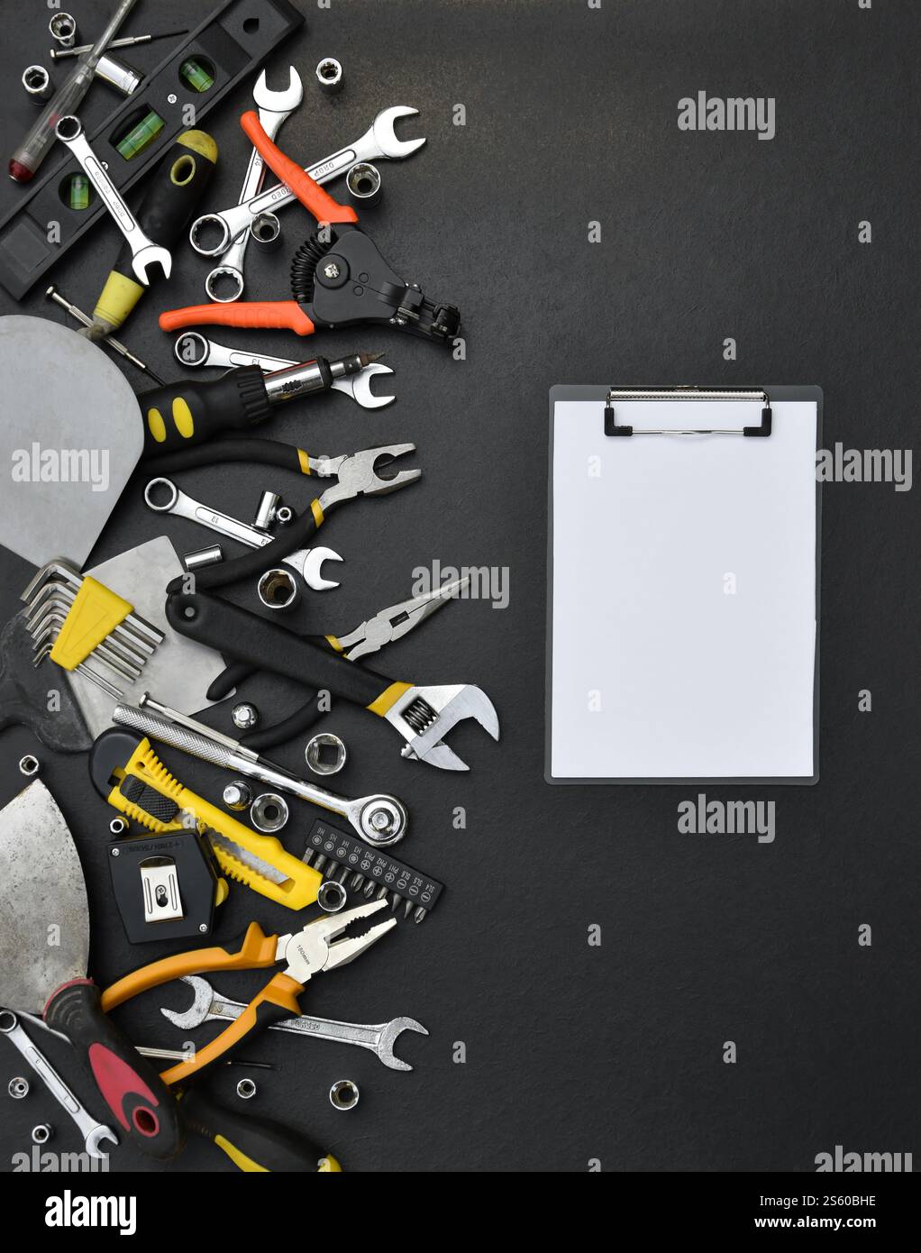 Kit d'outils bricoleur sur table en bois noir. De nombreuses clés et tournevis, pilers et autres outils pour tout type de travaux de réparation ou de construction. Banque D'Images