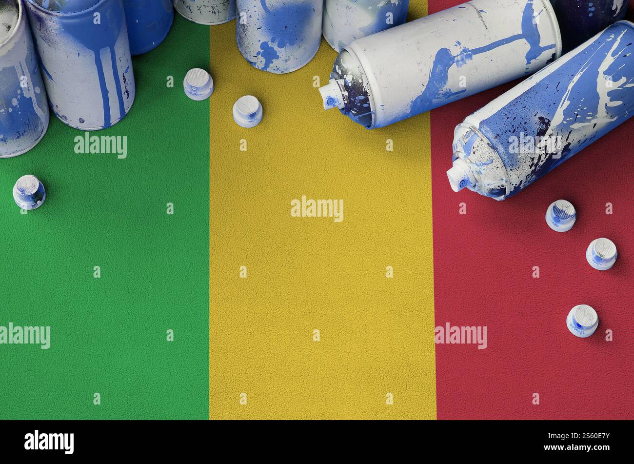 Mali drapeau et peu utilisé des bombes aérosol pour la peinture de graffiti. Concept de culture Street art, problèmes de vandalisme. Mali drapeau et peu utilisé aérosol spray Banque D'Images