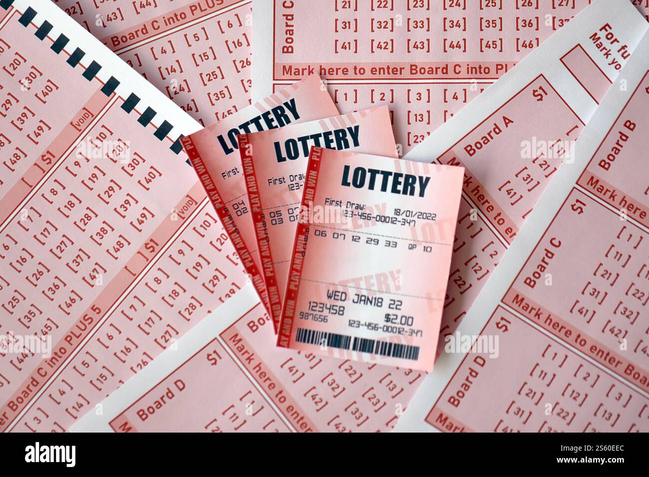 Billet de loterie rouge se trouve sur des feuilles de jeu roses avec des numéros pour marquer pour jouer à la loterie. Concept de jeu de loterie ou dépendance au jeu. Gros plan Banque D'Images