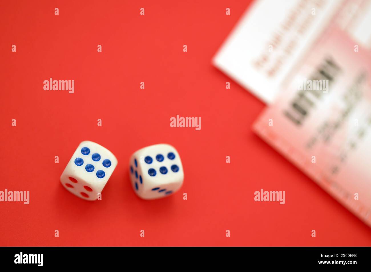 Billet de loterie rouge avec dés se trouve sur des feuilles de jeu roses avec des numéros pour marquer pour jouer à la loterie. Concept de jeu de loterie ou dépendance au jeu. Banque D'Images