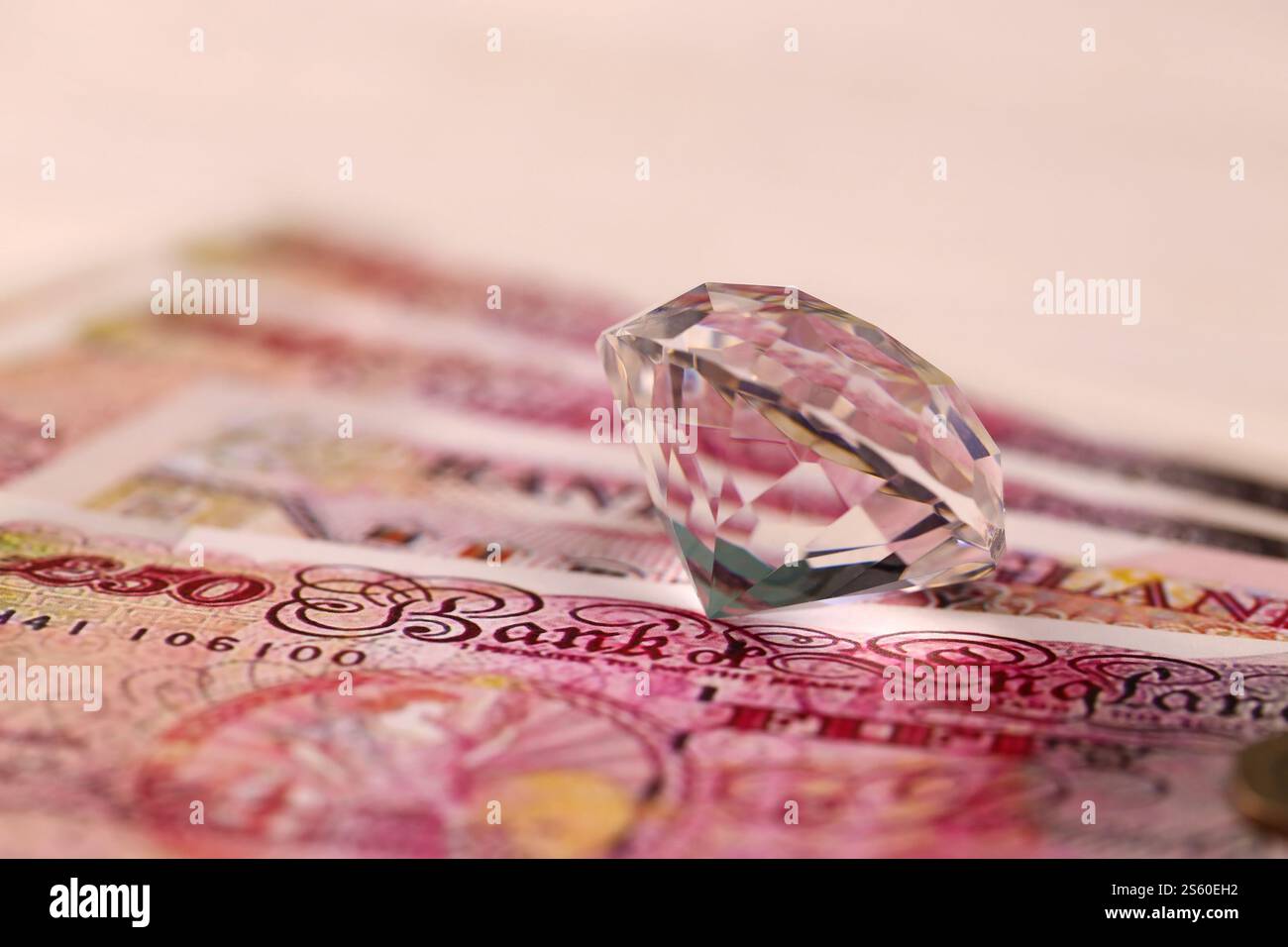 Billets d'argent au Royaume-Uni avec gros gros losanges. Grande quantité de livres du Royaume-Uni et énorme bijou transparent sur la table. Concept d'affaires et de bijoux pour Banque D'Images