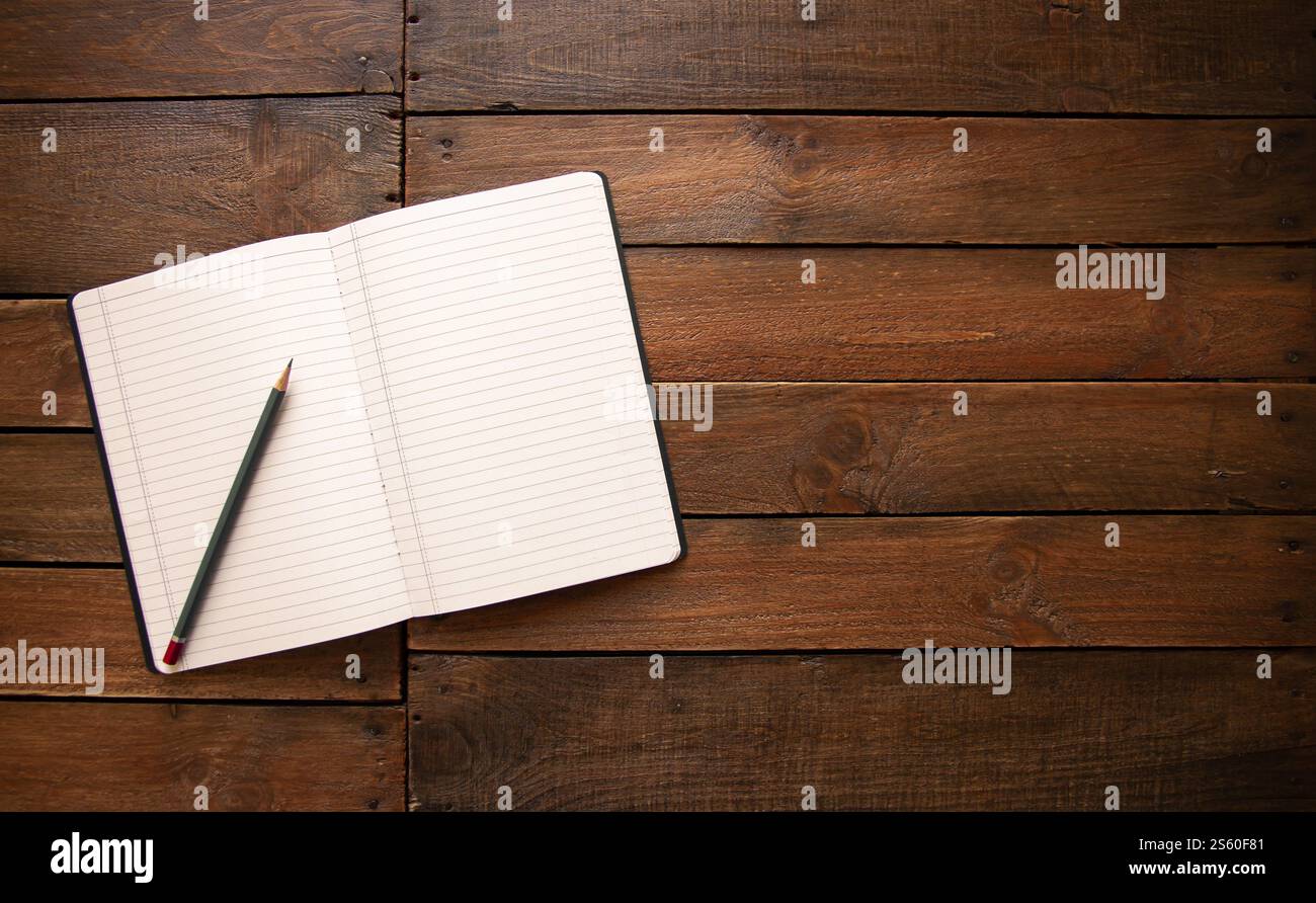 Ouvrez le carnet et le crayon sur une planche de bois vintage rustique. Ouvrez le cahier et le crayon sur une planche de bois rustique Banque D'Images